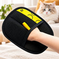 Hand wearing a black and yellow GetVelqo reusable pet hair remover glove with a fluffy cat in the background.