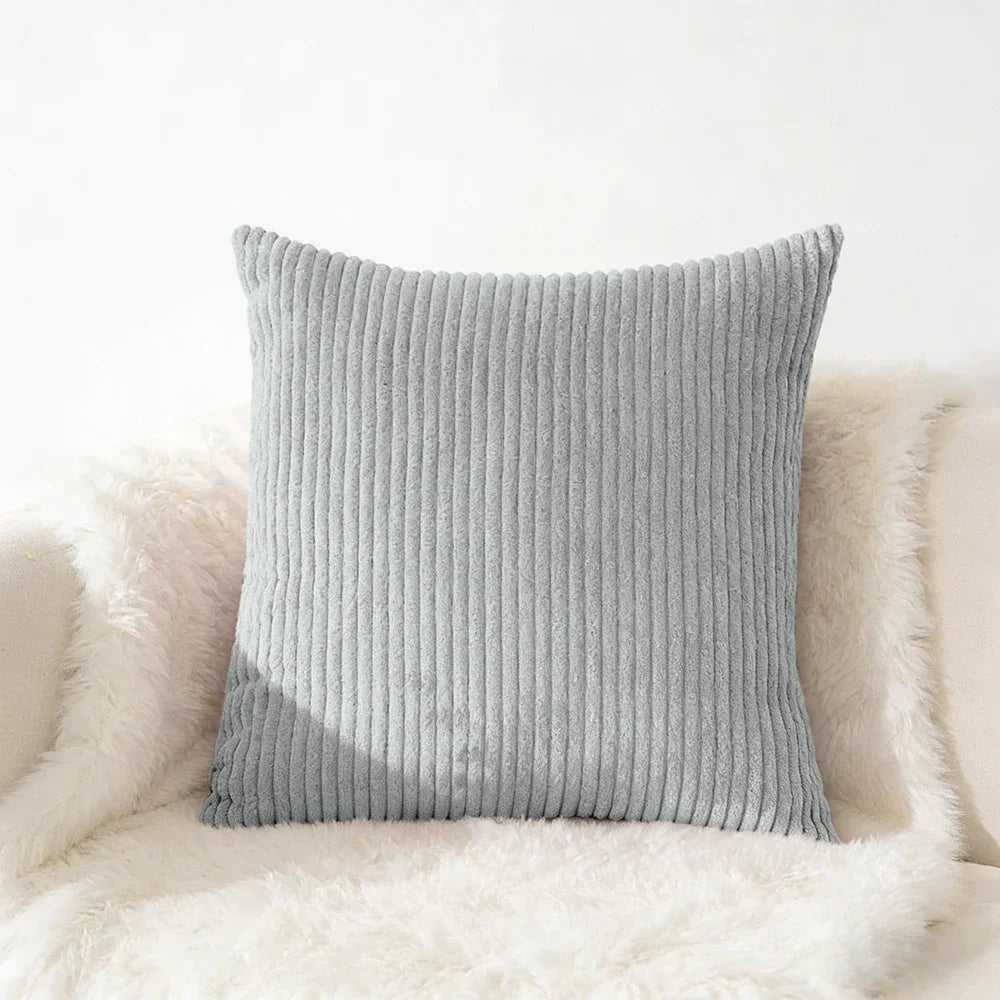 Gray corduroy throw pillow for cozy home décor on plush white fur
