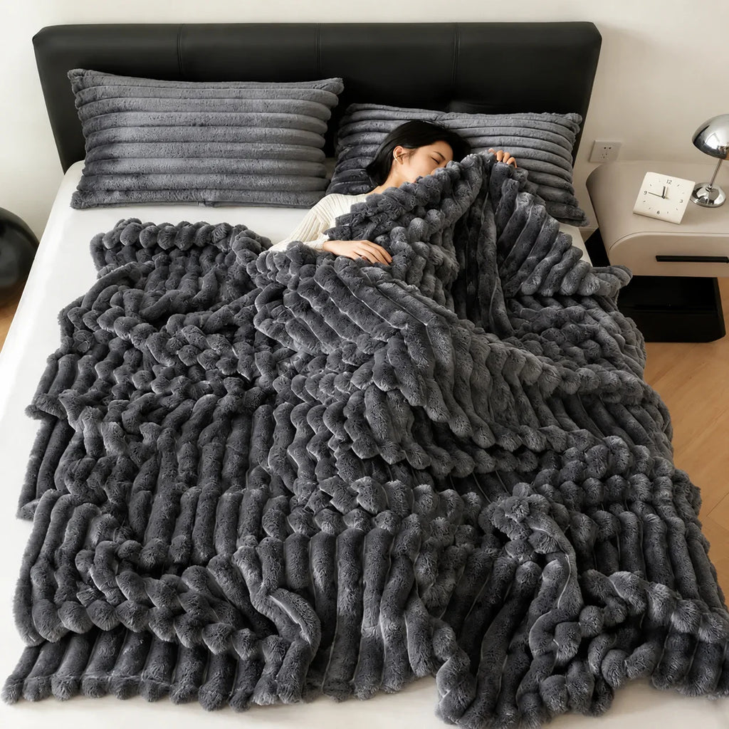 Gray plush braided throw blanket on bed with matching pillows, cozy bedroom decor