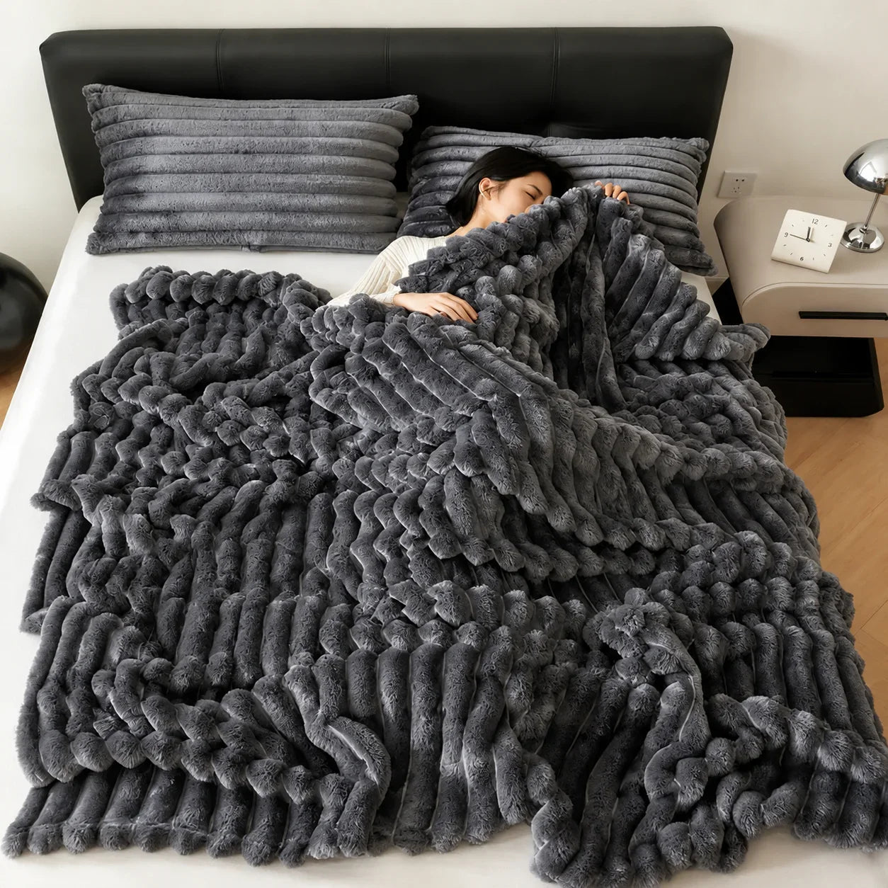 Gray plush braided throw blanket on bed with matching pillows, cozy bedroom decor