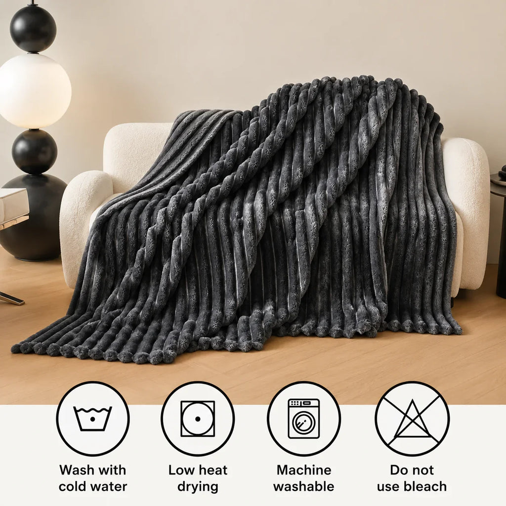 Gray plush ribbed throw blanket draped over cream armchair for cozy living room comfort