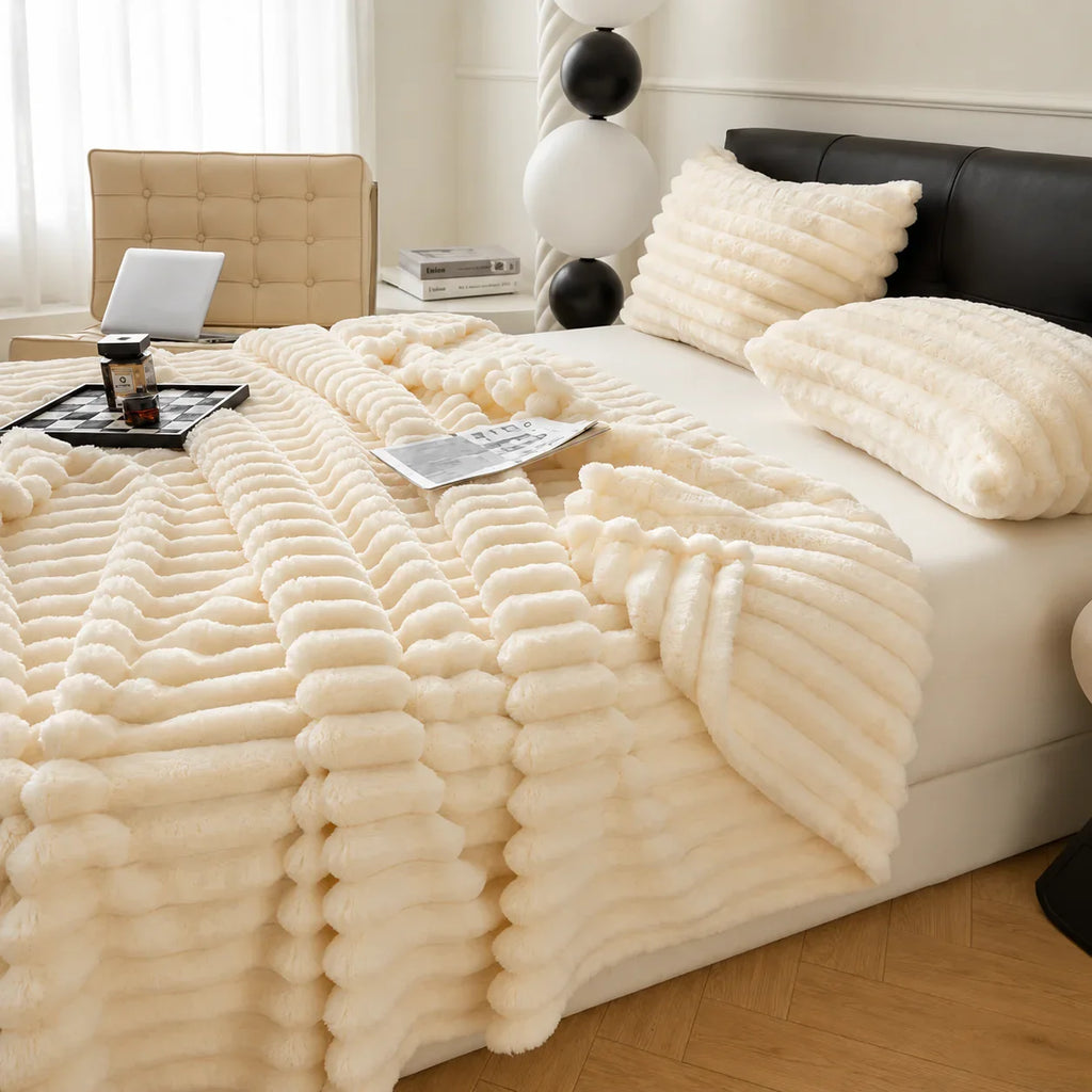 Cream faux fur throw blanket with ribbed texture on bed, cozy bedroom decor
