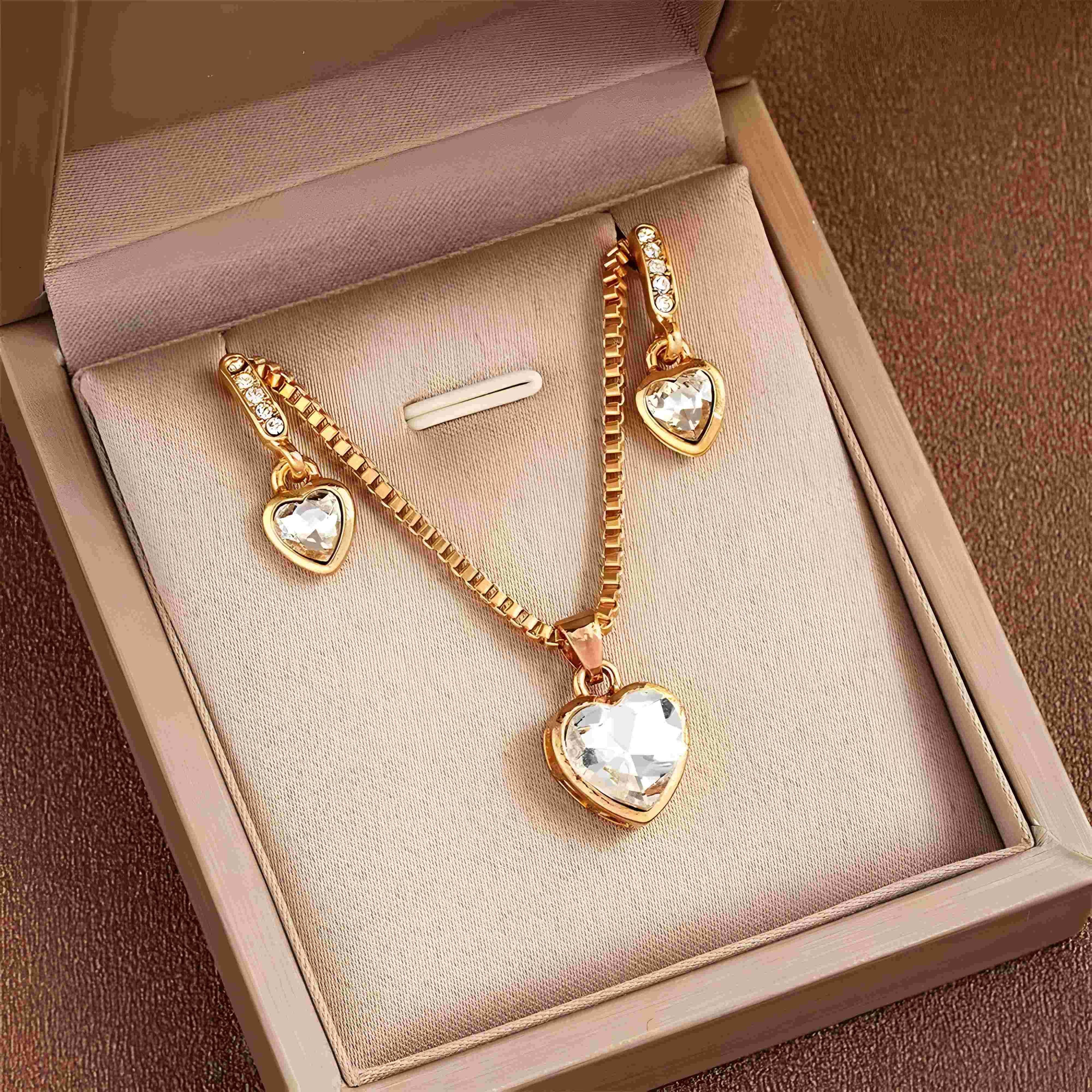 Gold heart pendant necklace and matching earrings with clear crystals, minimalist style