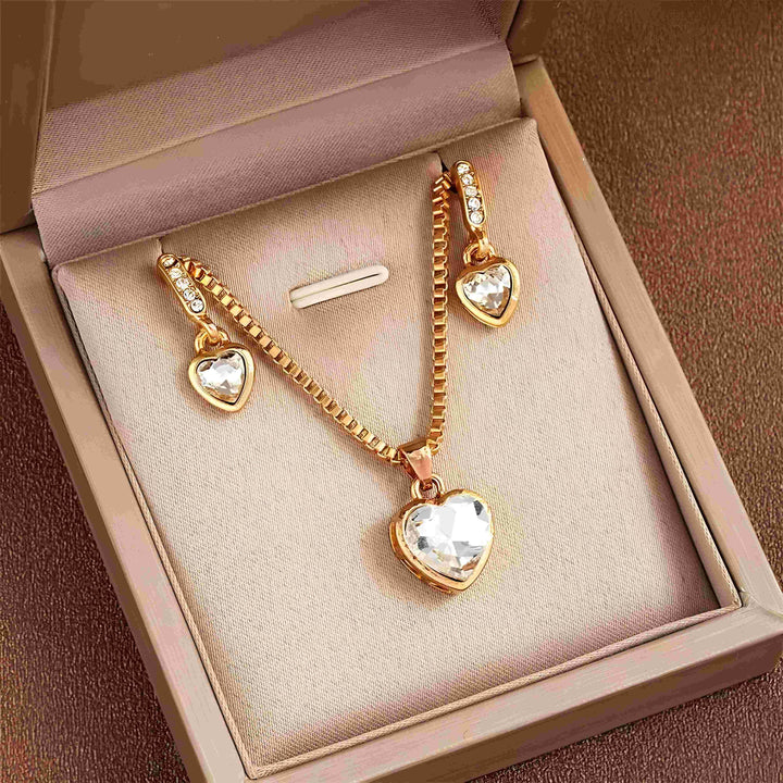 Gold heart pendant necklace and matching earrings with clear crystals, minimalist style