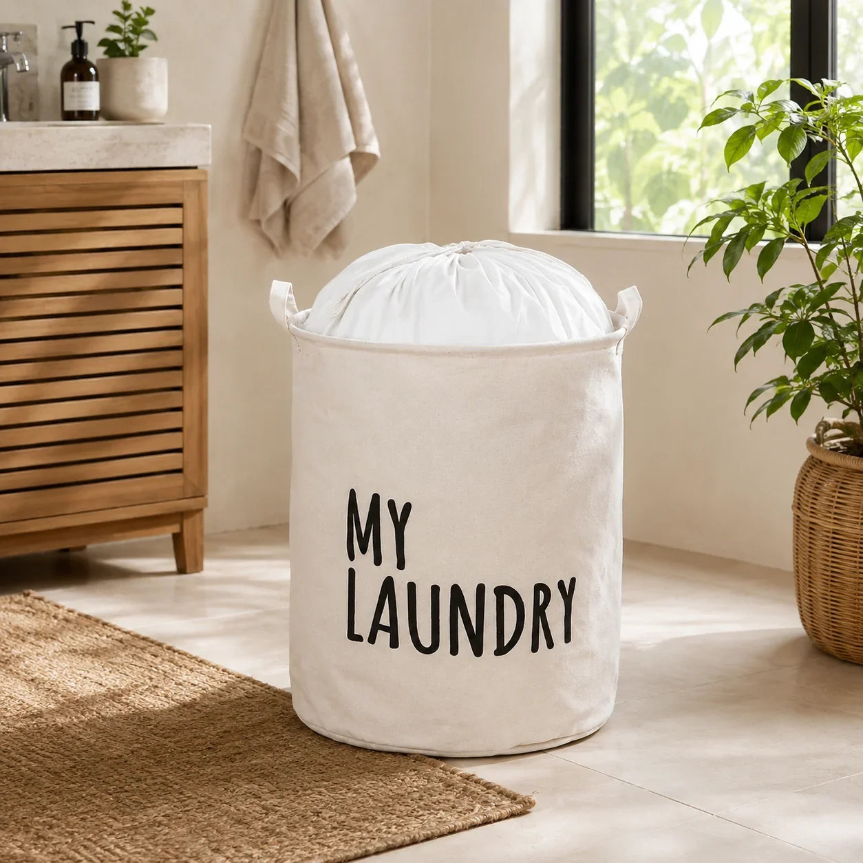 White canvas laundry hamper with 'MY LAUNDRY' text in a bathroom setting.