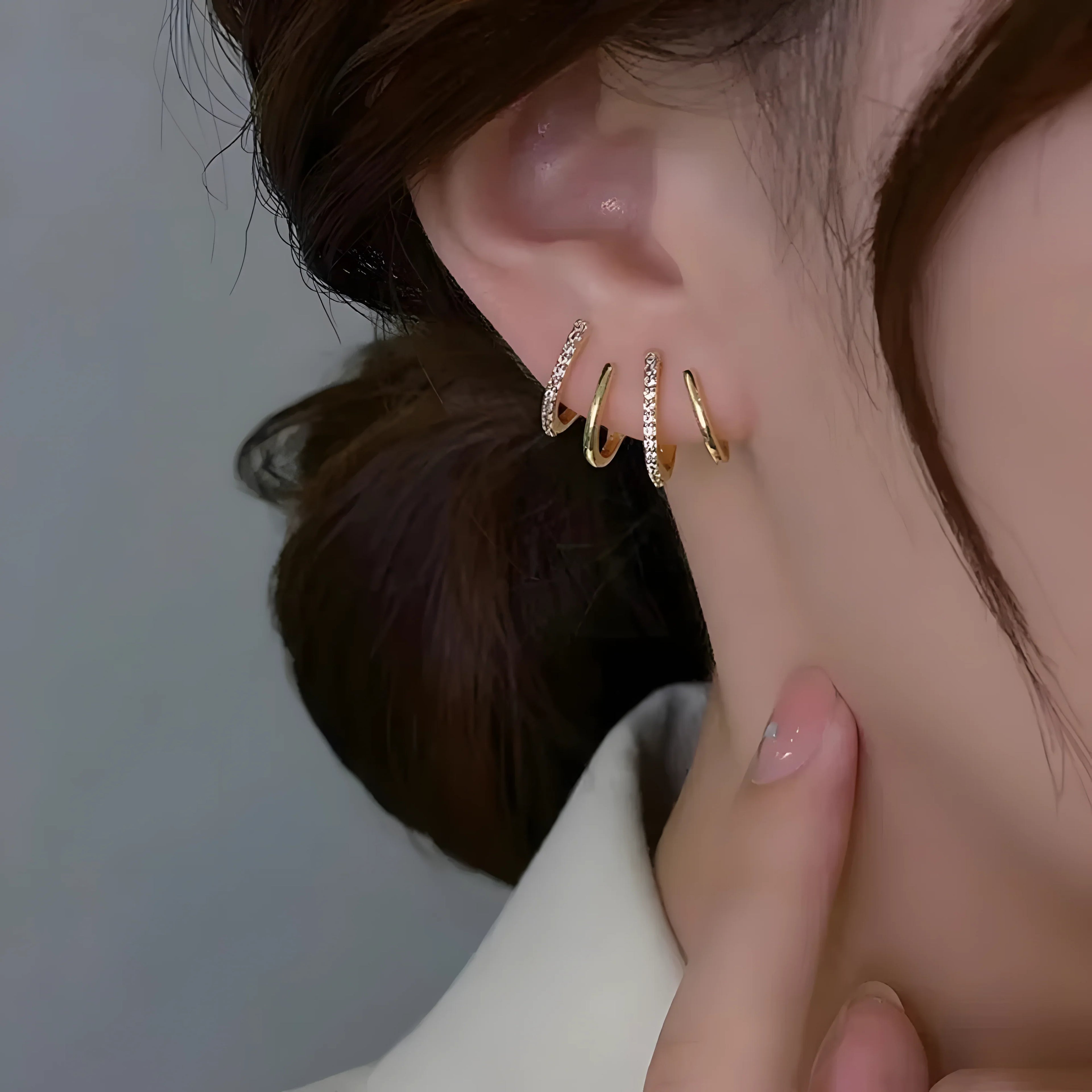 Four Claw Stud Set gold hoop earrings with cubic zirconia, minimalist style, shown on ear