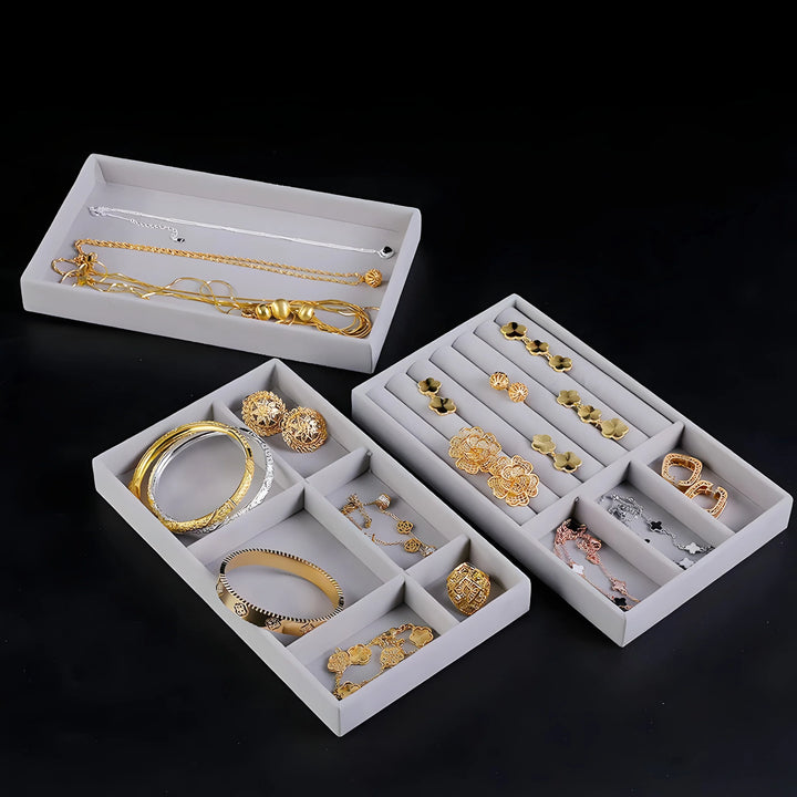 Gold and silver jewelry set with necklaces, bracelets, and earrings in elegant gray trays