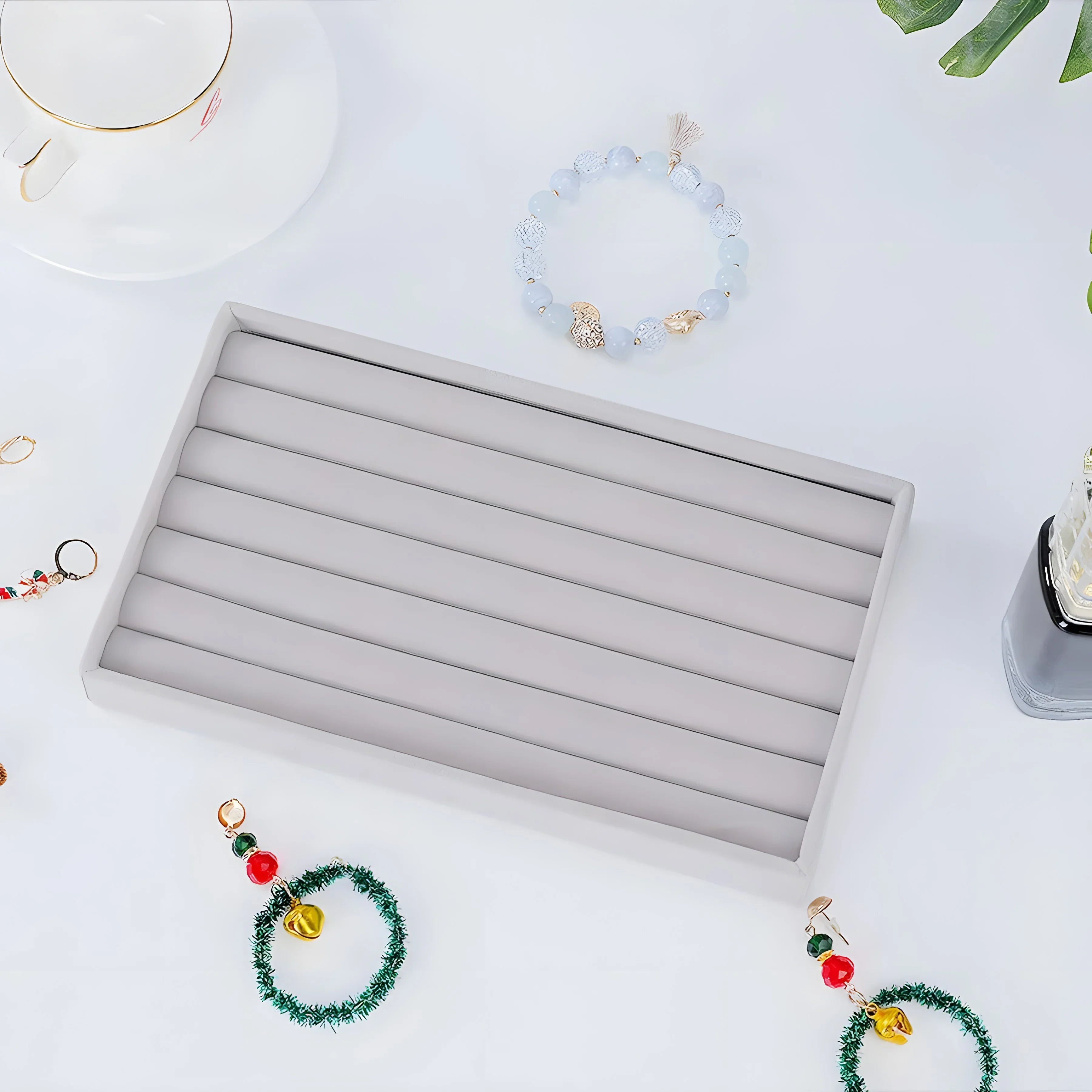 Light blue beaded bracelet with gold accents, minimalist style, on white surface with jewelry box and holiday decor