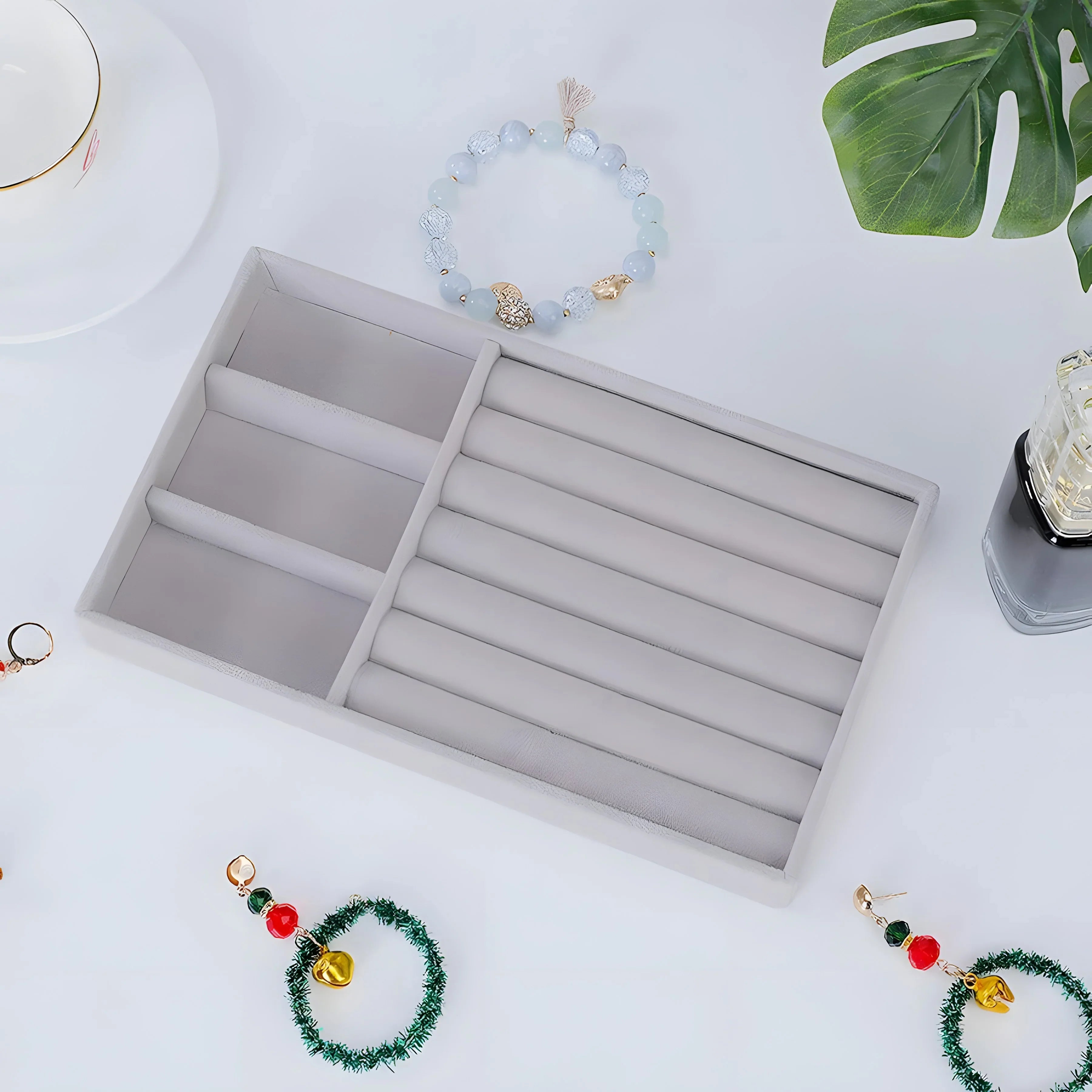 Light blue agate beaded bracelet with gold accents, minimalist style, displayed with jewelry box and green leaf