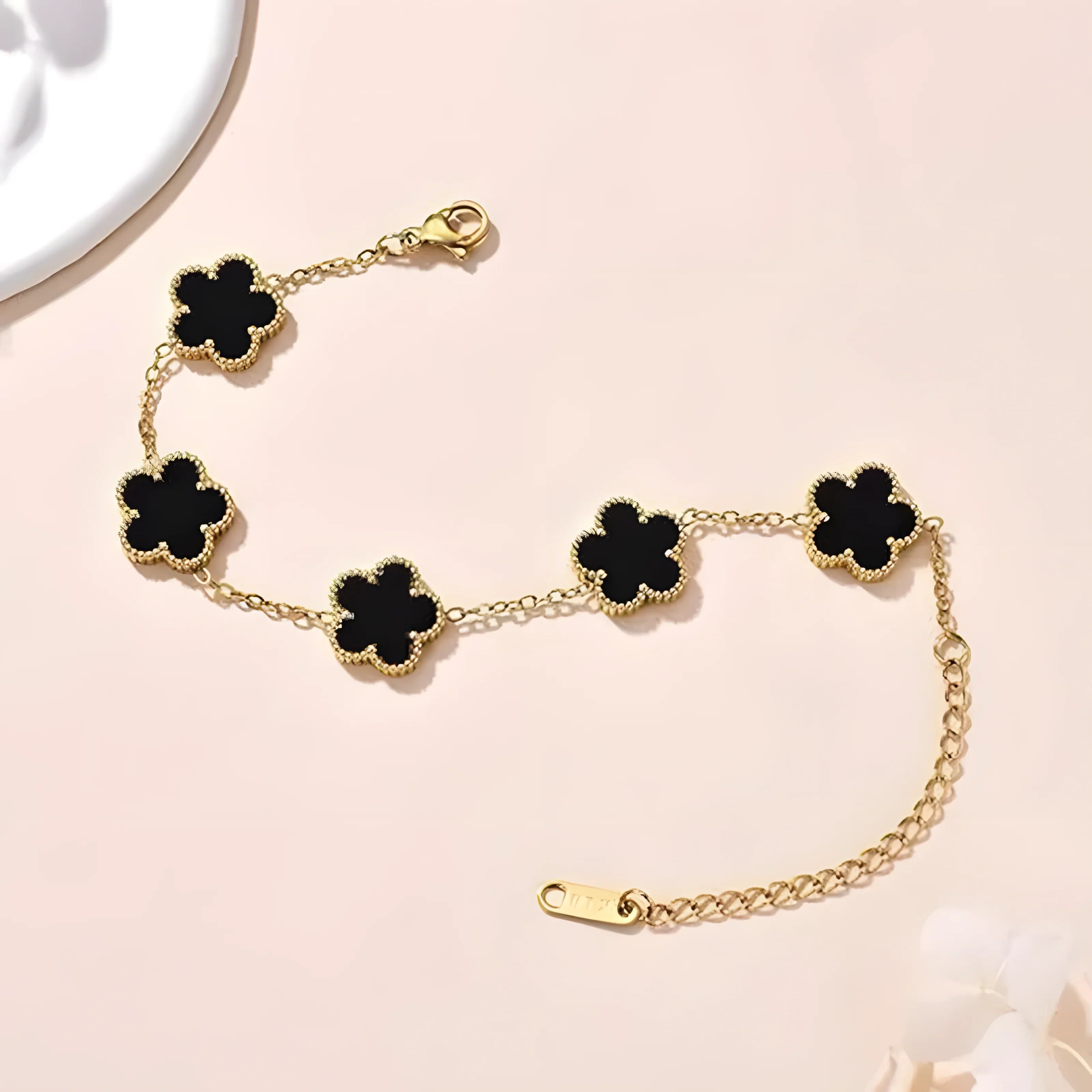 Gold bracelet with black clover charms, minimalist style, everyday elegance