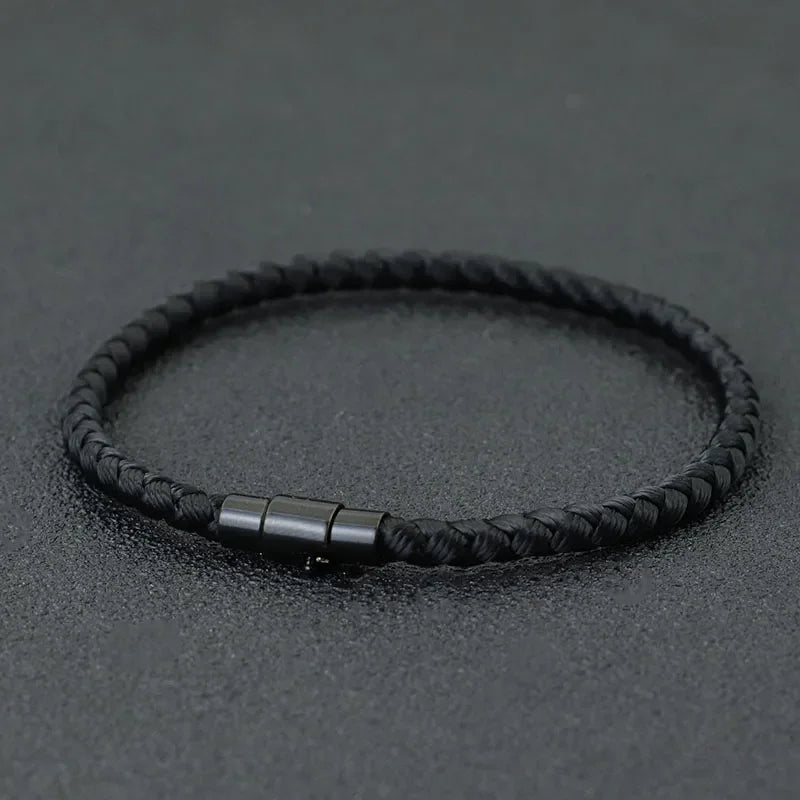 Lucky Thread Bracelet black braided cord minimalist jewelry with metal clasp on dark background