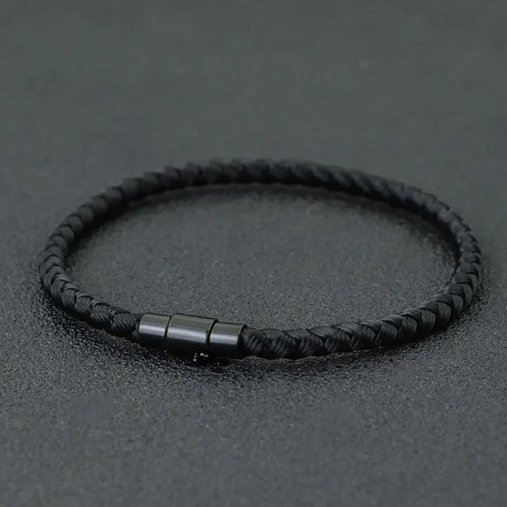 Lucky Thread Bracelet black braided cord minimalist jewelry with metal clasp on dark background