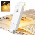 White clip-on book light with warm LED, illuminating pages for reading