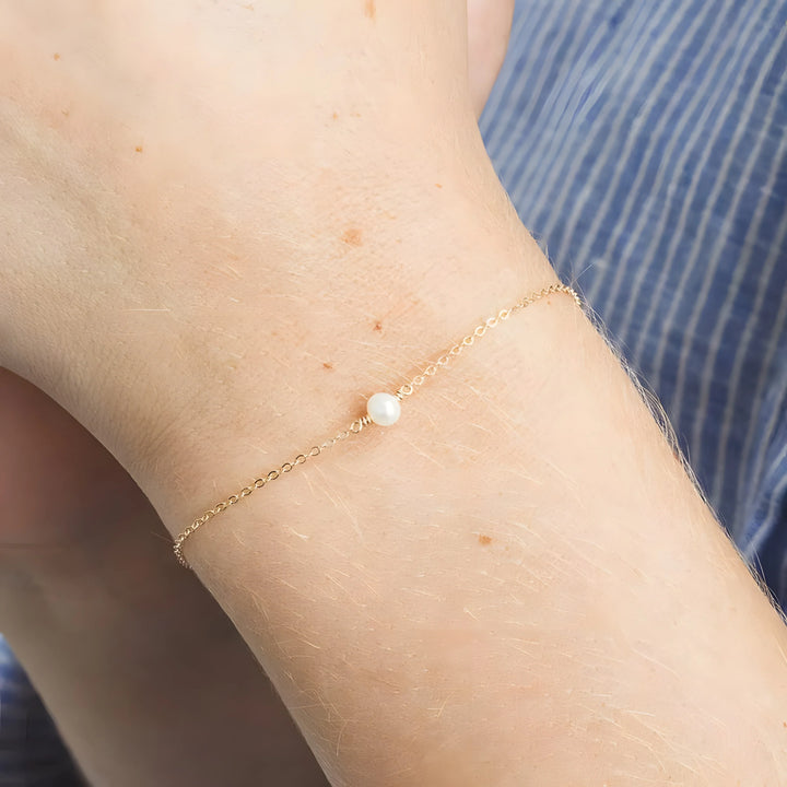 Gold chain bracelet with single white pearl, minimalist design for everyday wear