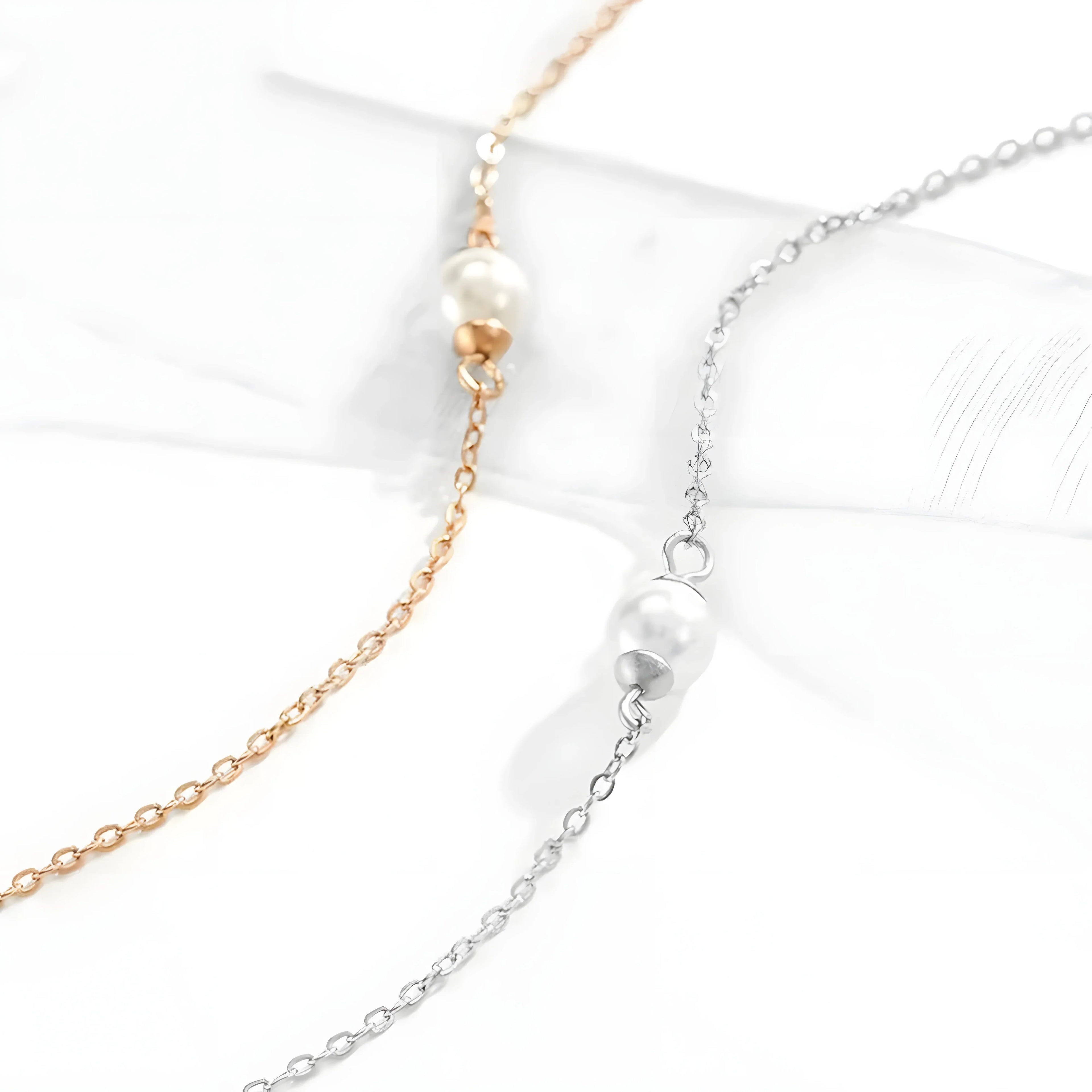 Minimalist pearl necklace in gold and silver tones, featuring delicate chain and single pearl pendant for everyday elegance