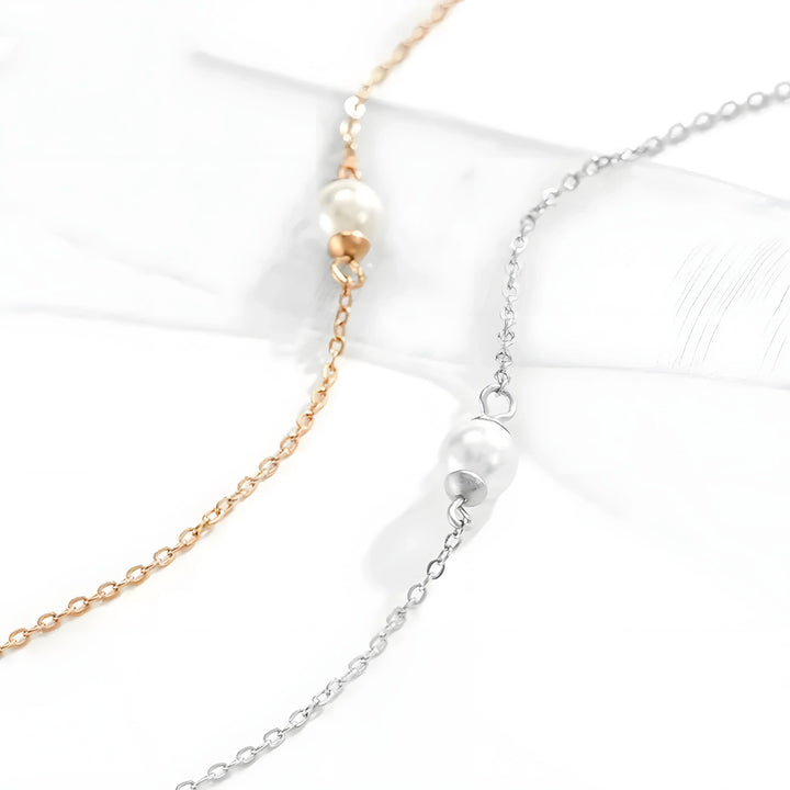 Minimalist pearl necklace in gold and silver tones, featuring delicate chain and single pearl pendant for everyday elegance