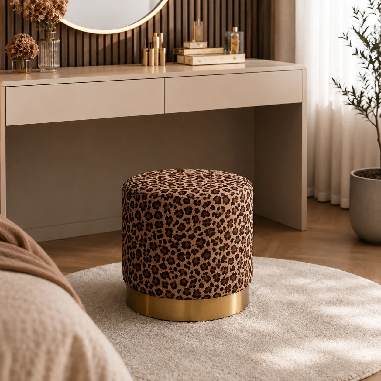 Round leopard print ottoman with gold base, styled in bedroom near vanity for seating or decor