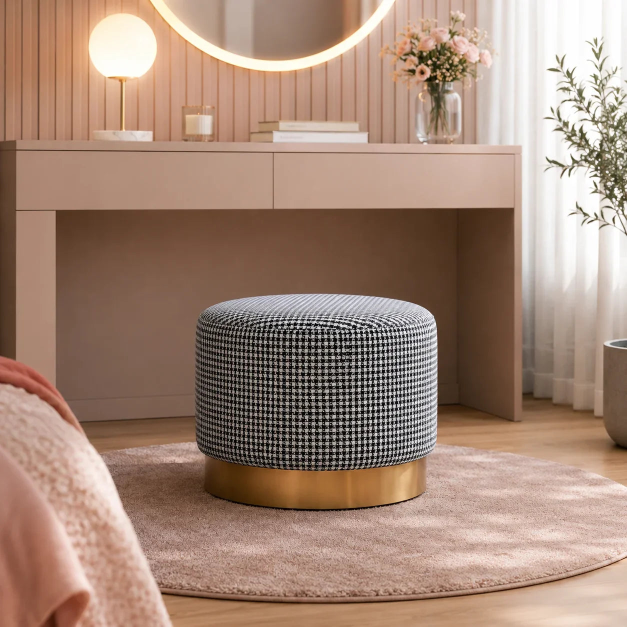 Round houndstooth ottoman with gold base, styled in bedroom for seating or decor