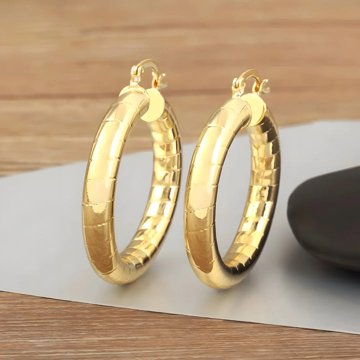 Minimal hoop earrings in gold-tone metal with textured finish, modern classic jewelry style