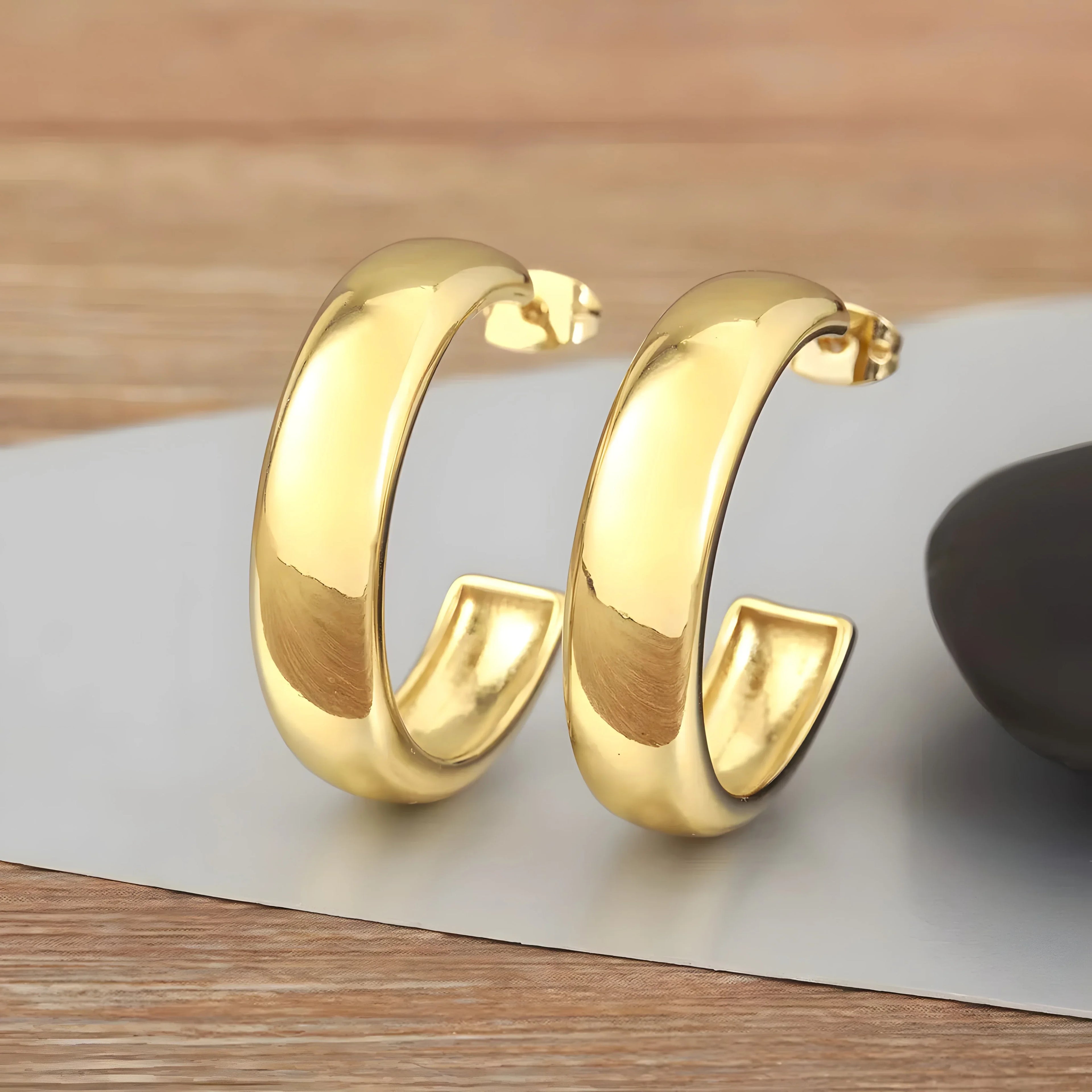 Minimal gold hoop earrings, polished finish, thick band, modern and elegant jewelry style