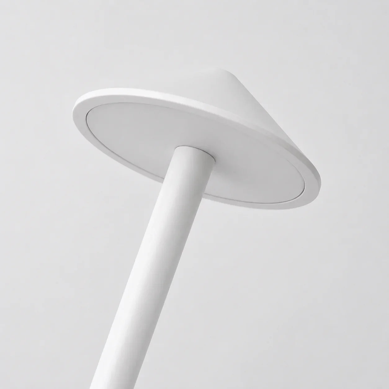 White modern floor lamp with sleek cylindrical base and wide circular shade for ambient lighting