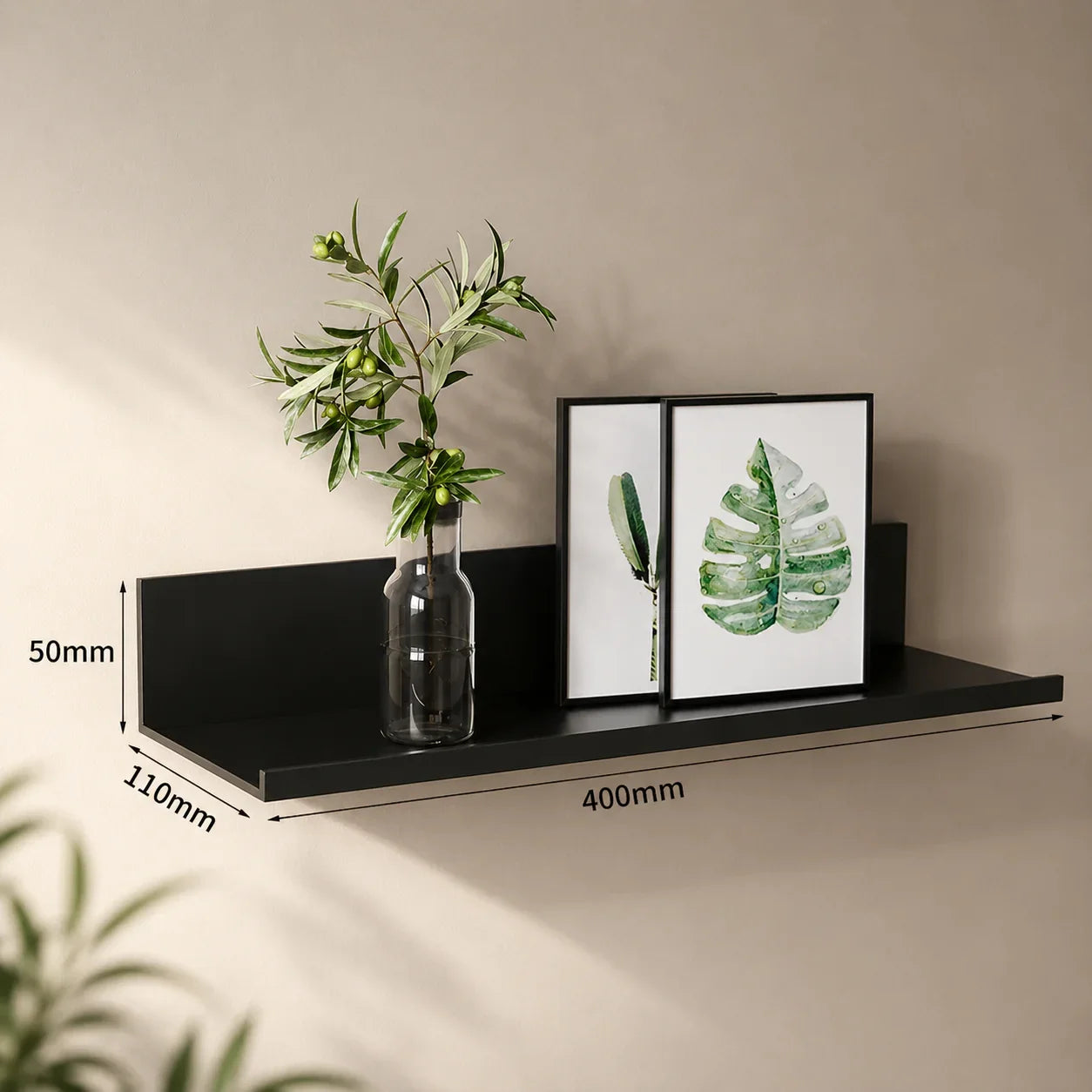 Black metal wall shelf with plant and framed leaf art, ideal for home decor and organization