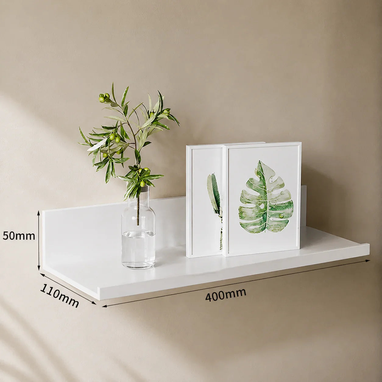 White floating shelf with green plant and leaf art, ideal for home decor and organization