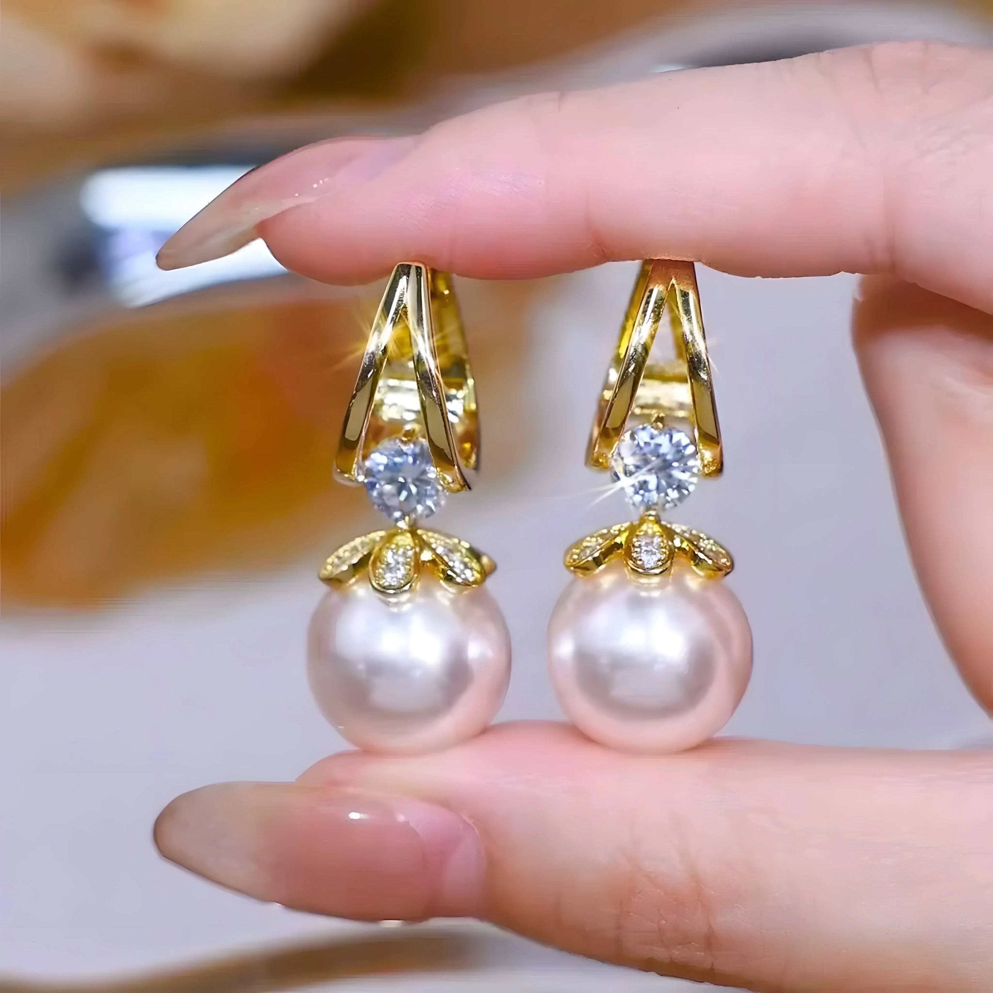 Gold pearl drop earrings with crystal accents, minimalist luxury design