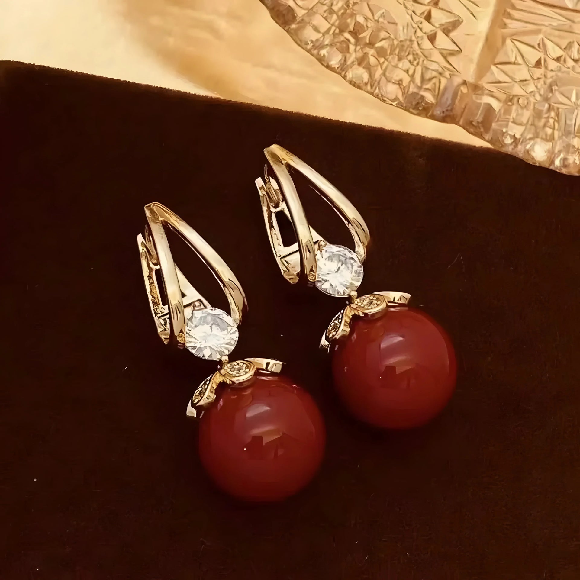 Gold hoop earrings with red carnelian beads and clear crystals, minimalist style
