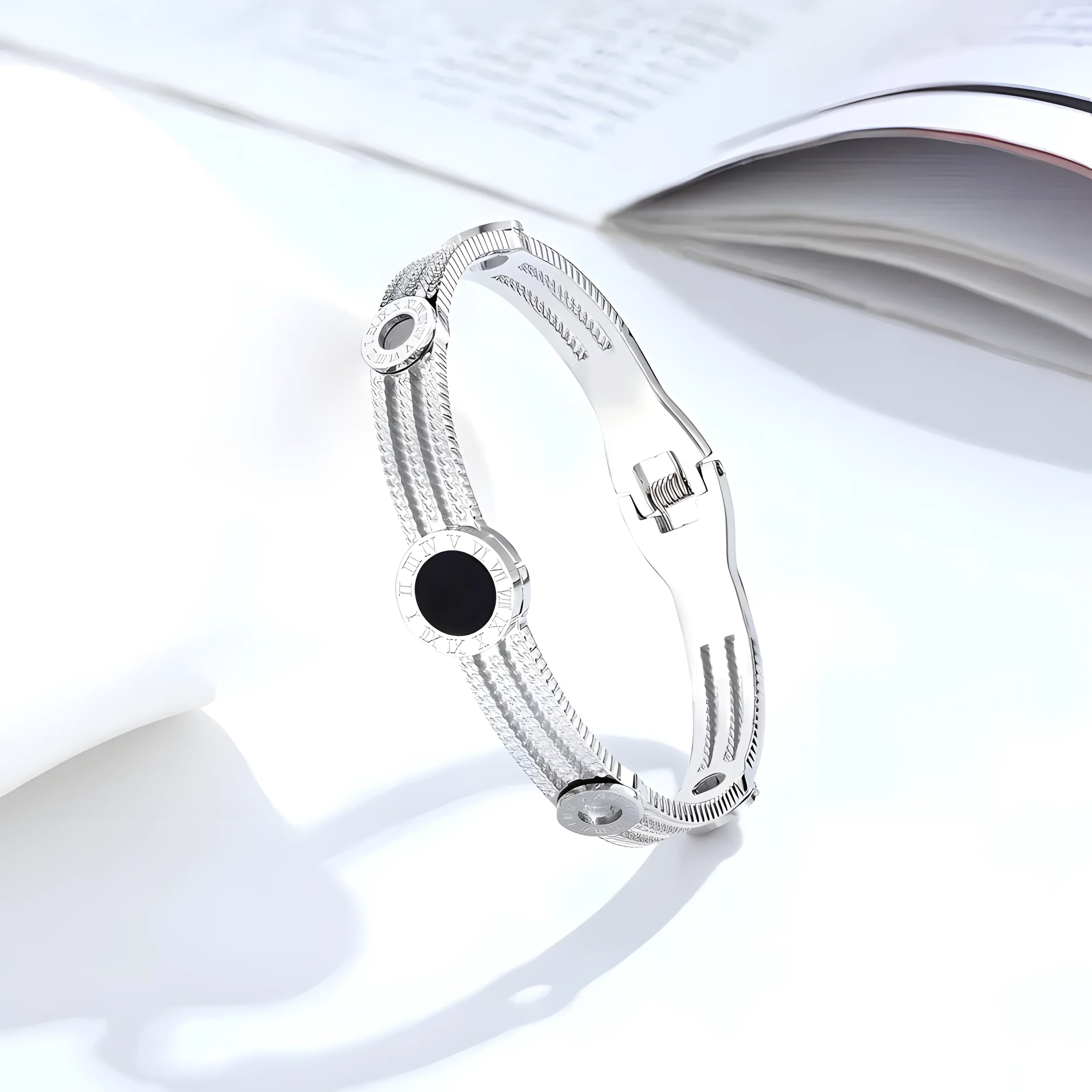 Silver bangle bracelet with black dial, Roman numerals, textured band, minimalist style