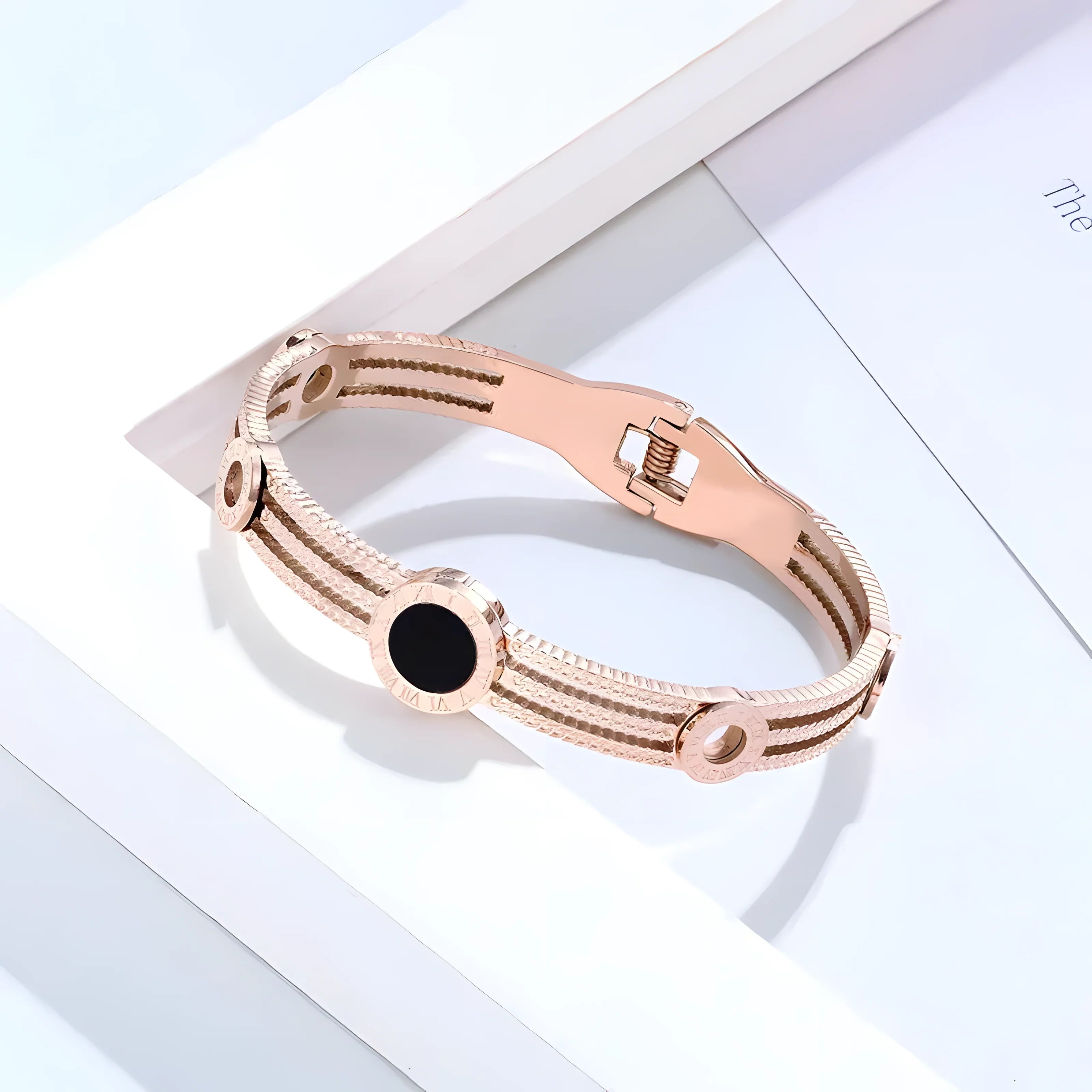 Rose gold bangle bracelet with black stone, minimalist design, textured bands, elegant everyday jewelry