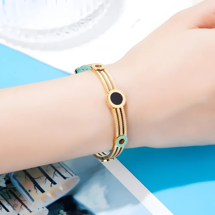 Gold bracelet with black and mint accents, minimalist style, textured design