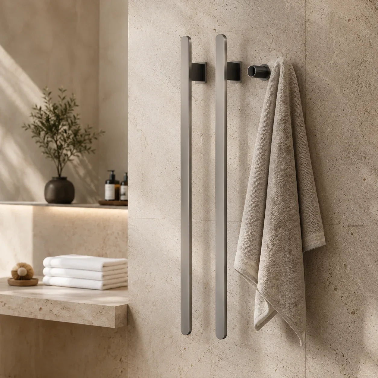 Modern brushed nickel towel bars mounted on beige stone wall, holding a beige towel in a minimalist bathroom.