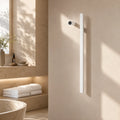 White modern bathroom towel warmer with digital temp display mounted on beige wall