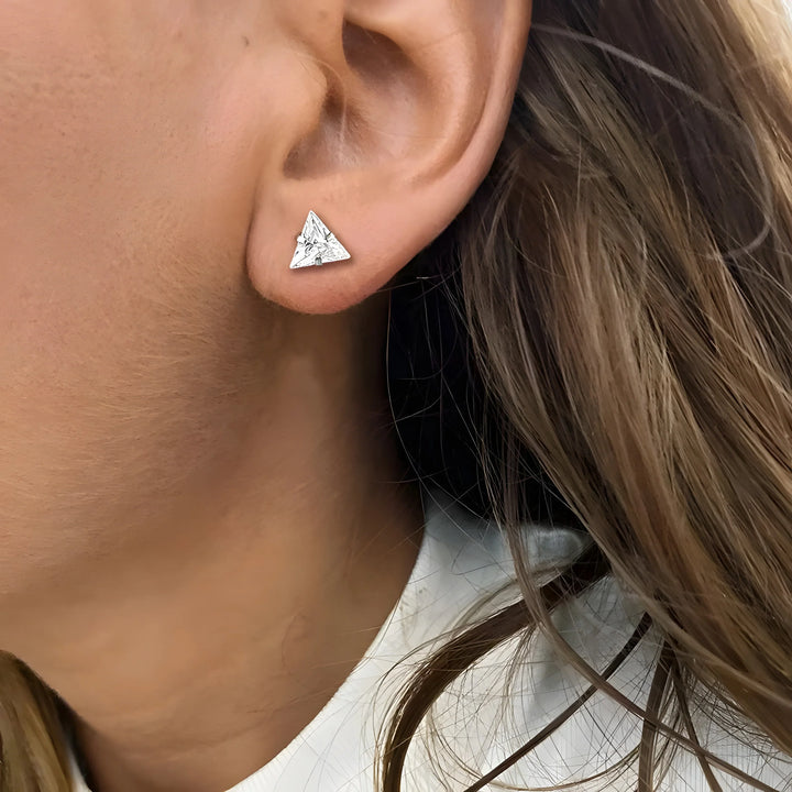 Silver triangle stud earring with geometric design, minimalist style, worn on earlobe