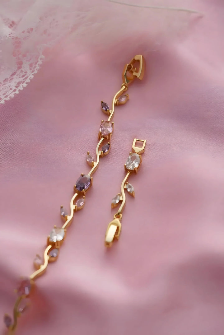 Gold vine-style bracelet with pink and clear gemstones, elegant minimal design