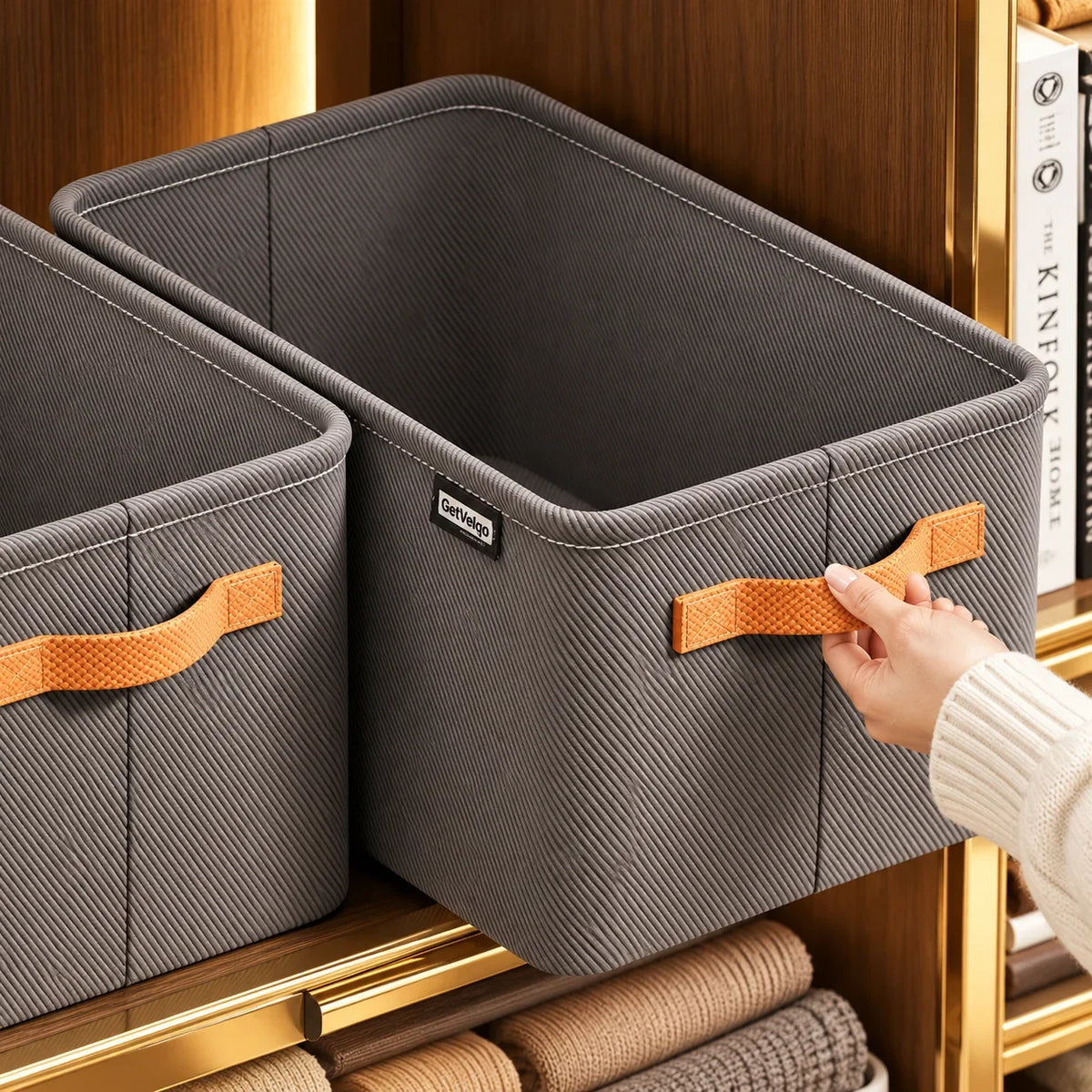 Grey GetVelqo fabric storage bins with brown handles on a wooden shelf.