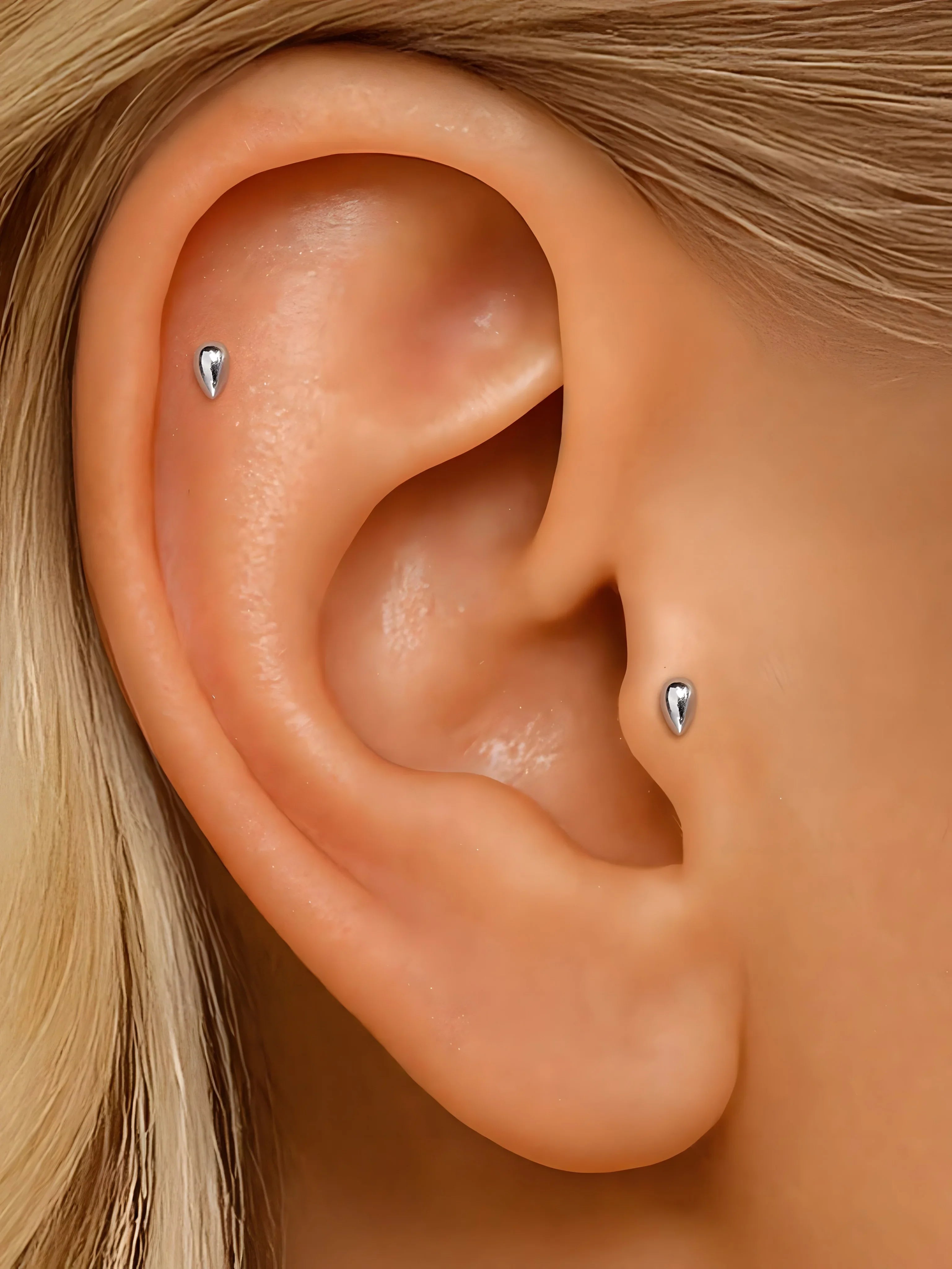 Zircon stud earrings, silver color, minimalist teardrop style, worn on ear