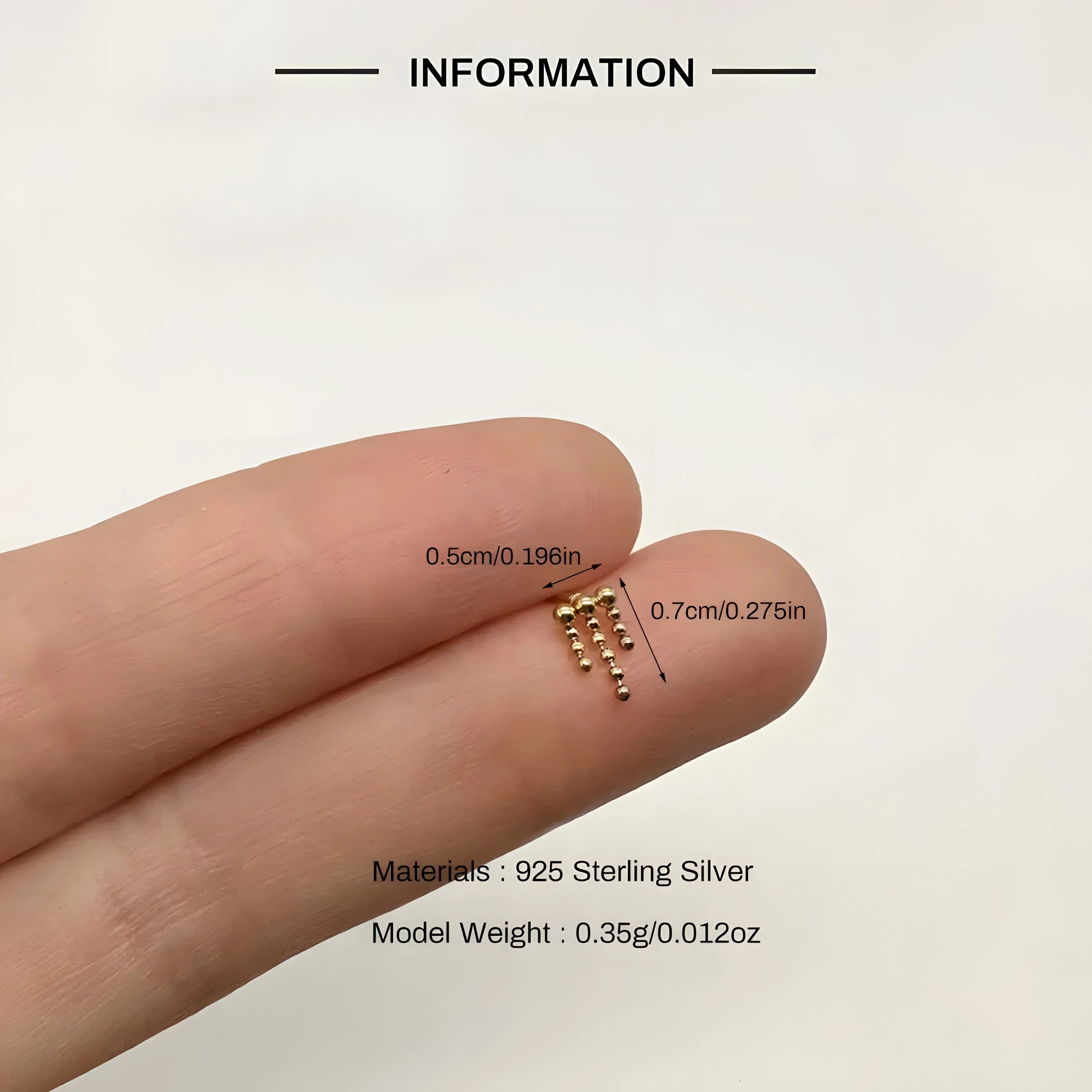Gold zircon stud earrings made of 925 sterling silver, minimal beaded design, shown on hand.
