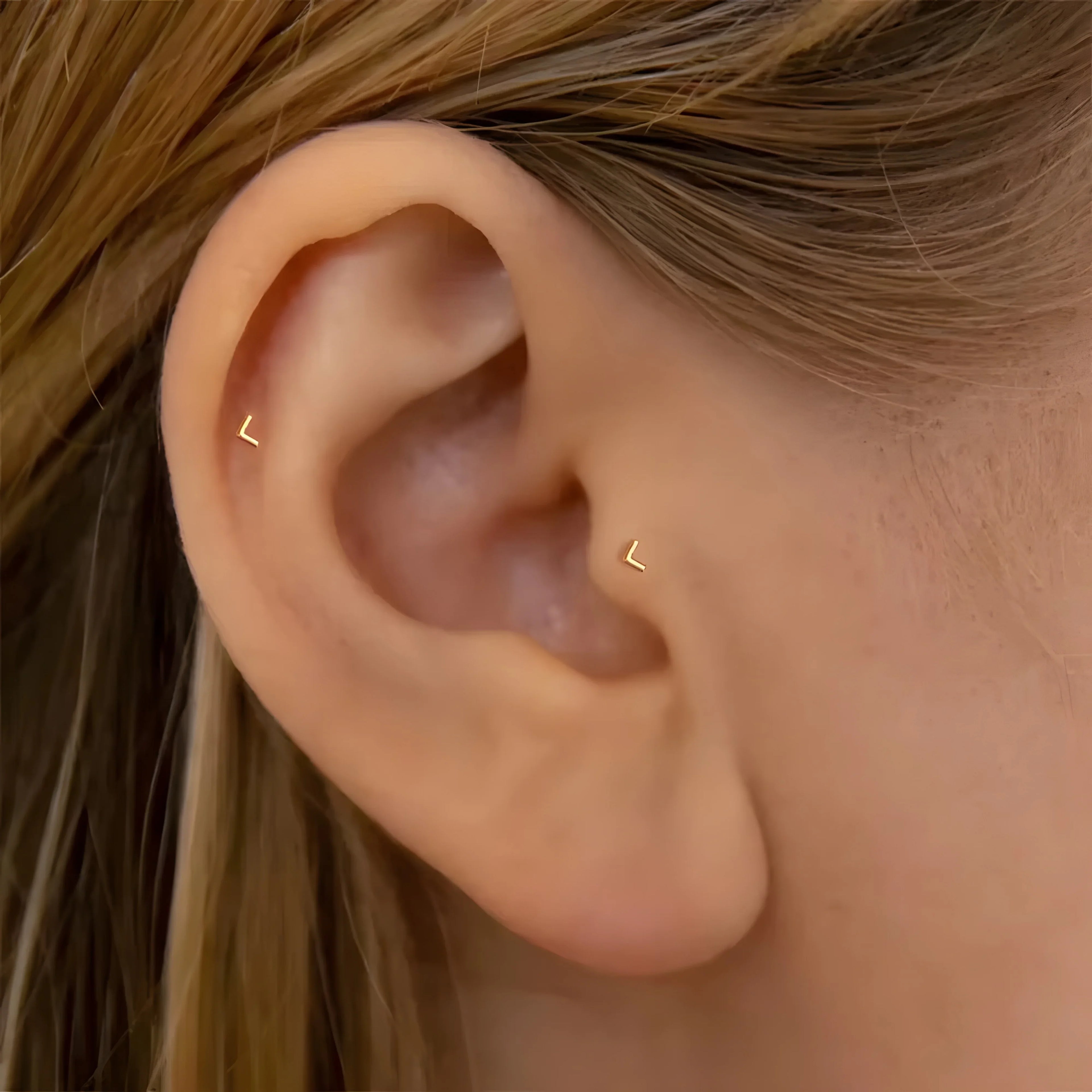 Zircon stud earrings gold minimalist style shown on ear, modern geometric jewelry